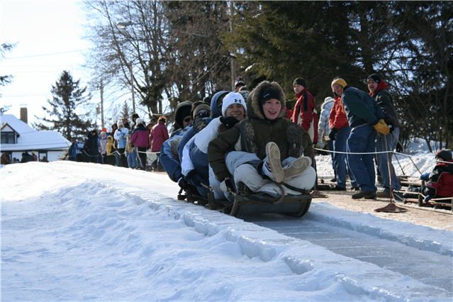 Five people ride a toboggan down an ice chute in Eagles Mere